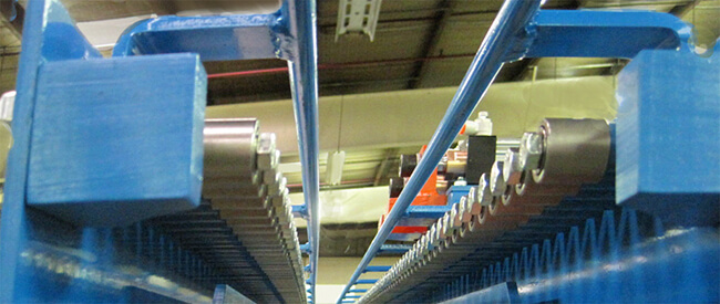 Gravity Flow Conveyor designed to feed and transfer steel flanged product in a machining cell.