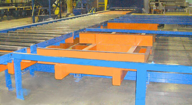 A custom Lift-and-Carry Shuttle Transfer used to accumulate long aluminum beams after exiting an automatic shot-blasting process.